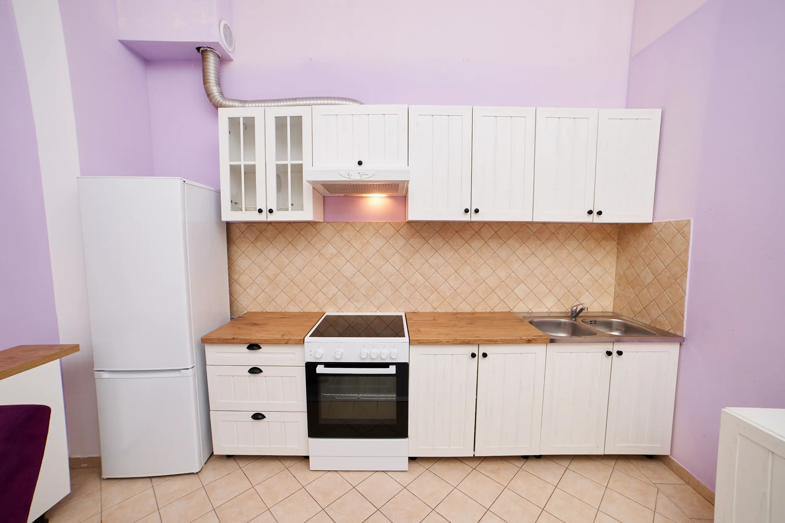 Kitchen with pastel interior painting and white cabinets.